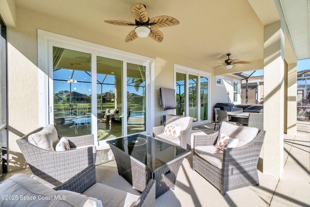 view of patio / terrace featuring outdoor lounge area, ceiling fan, and glass enclosure