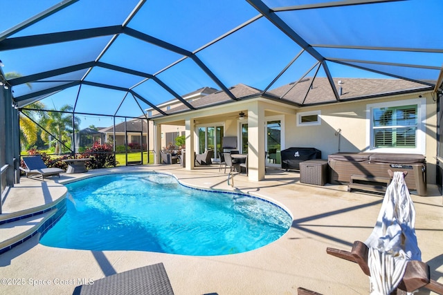 view of swimming pool featuring ceiling fan, a patio, glass enclosure, and a hot tub