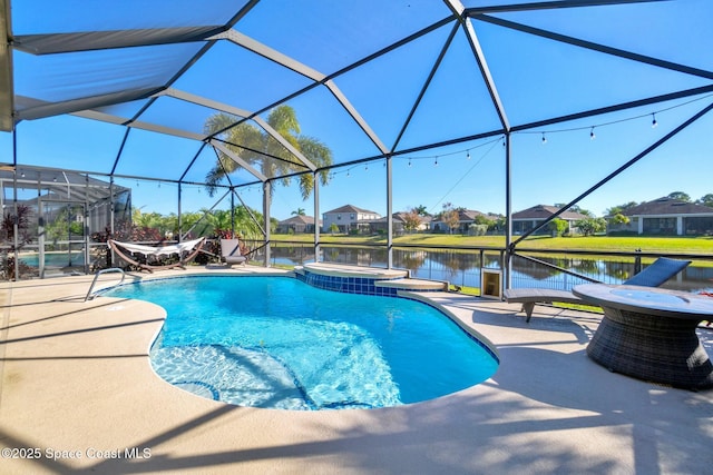 view of pool with an in ground hot tub, a water view, a patio area, and a lanai