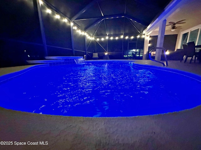 pool at twilight featuring a jacuzzi and ceiling fan