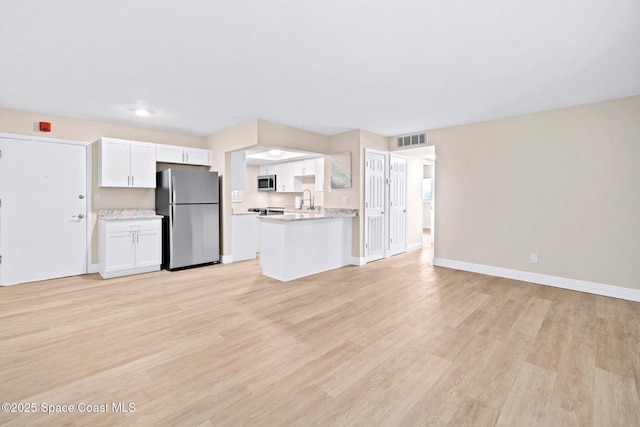 230 Columbia Dr Unit 113, Cape Canaveral, FL 32920 - kitchen featuring appliances with stainless steel finishes, open floor plan, light countertops, and white cabinetry