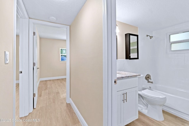 230 Columbia Dr Unit 113, Cape Canaveral, FL 32920 - bathroom featuring wood finished floors, vanity, bathing tub / shower combination, a textured ceiling, and healthy amount of natural light