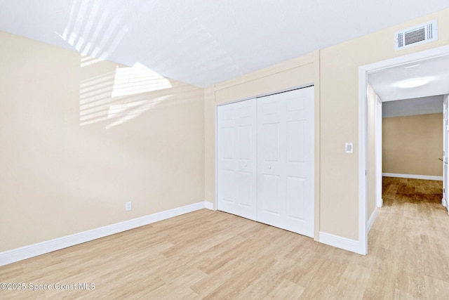 unfurnished bedroom with light hardwood / wood-style floors and a closet