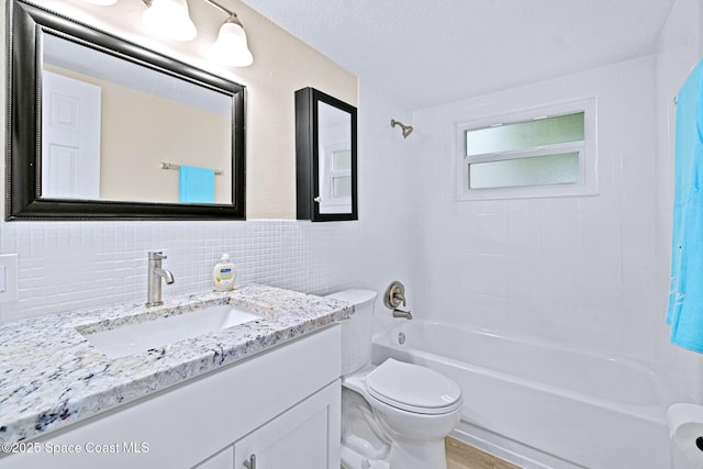 full bathroom featuring decorative backsplash, a textured ceiling, vanity, shower / washtub combination, and toilet