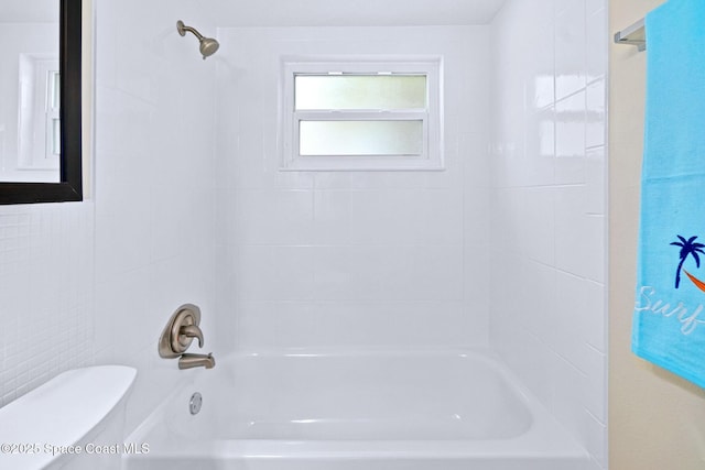 bathroom with bathtub / shower combination and toilet