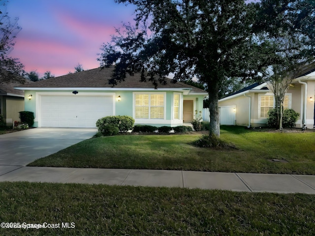 single story home featuring a yard and a garage