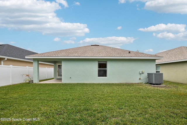 back of property with central AC unit, a lawn, and a patio area