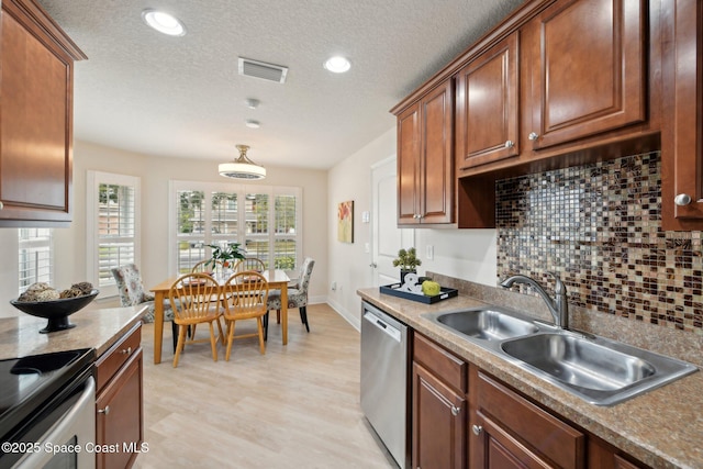 kitchen with sink, backsplash, stainless steel dishwasher, a textured ceiling, and light hardwood / wood-style flooring