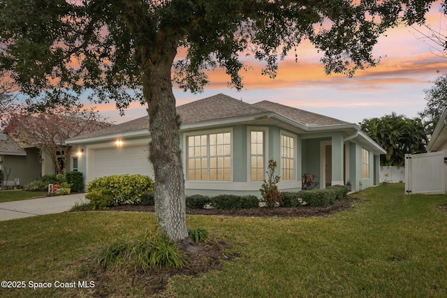 property exterior at dusk featuring a garage and a yard