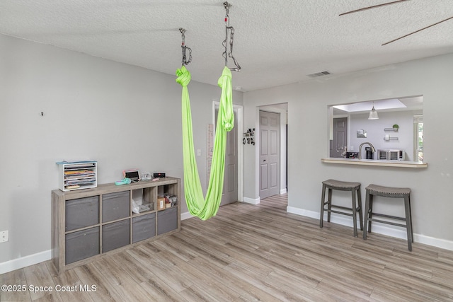 misc room with ceiling fan, wood-type flooring, and a textured ceiling