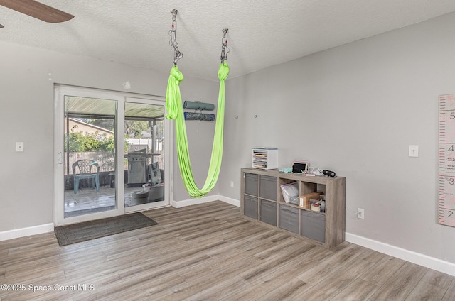 spare room with ceiling fan, wood-type flooring, and a textured ceiling