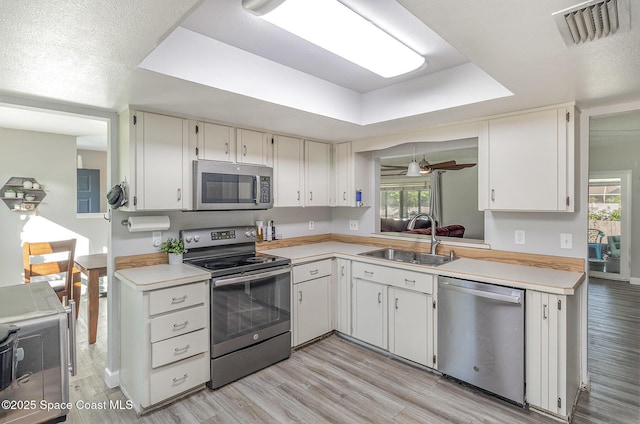 kitchen featuring a wealth of natural light, white cabinetry, sink, and stainless steel appliances