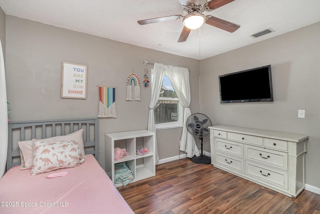 bedroom with a textured ceiling, dark hardwood / wood-style flooring, and ceiling fan