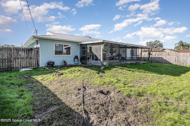 back of property with a sunroom and a lawn