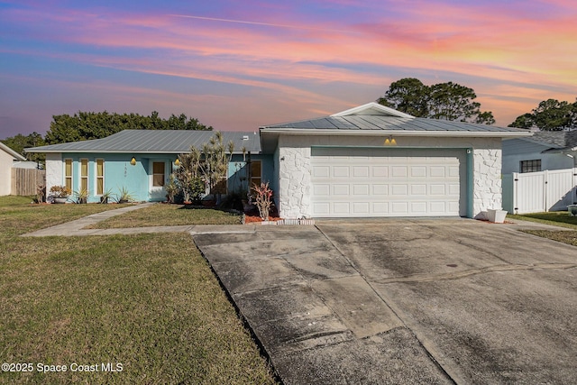 ranch-style house with a garage and a lawn