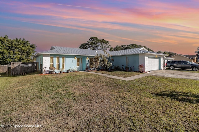 ranch-style home featuring a lawn and a garage