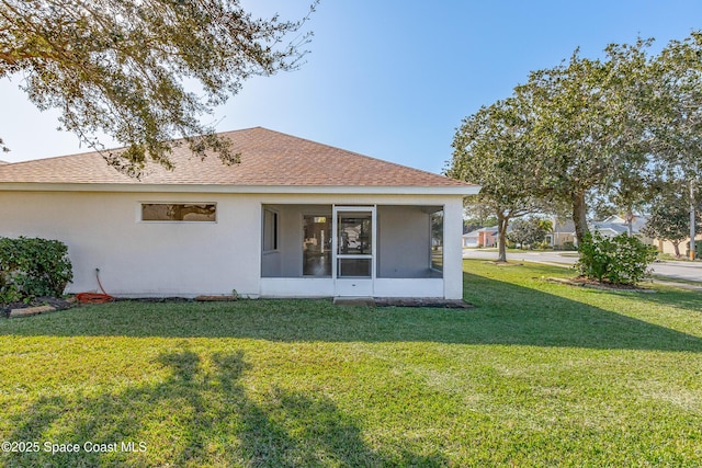 back of property with a sunroom and a yard