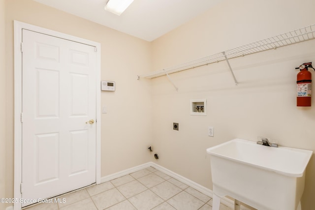 washroom with hookup for an electric dryer, hookup for a washing machine, tile patterned floors, and sink