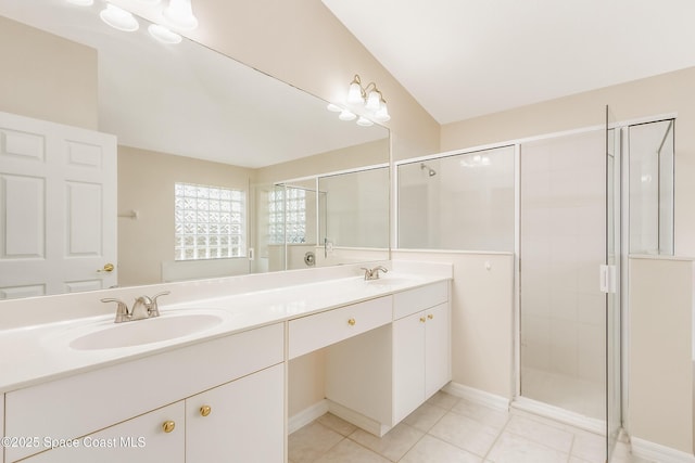 bathroom with tile patterned flooring, vanity, and walk in shower