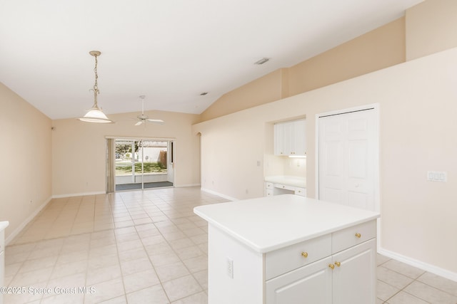 kitchen with vaulted ceiling, ceiling fan, decorative light fixtures, a kitchen island, and white cabinetry