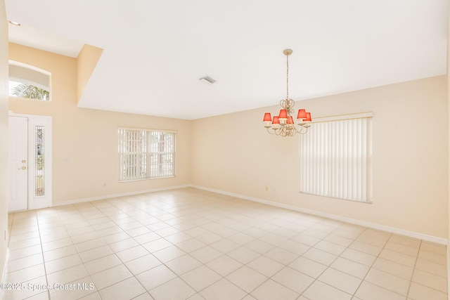 tiled empty room with a notable chandelier