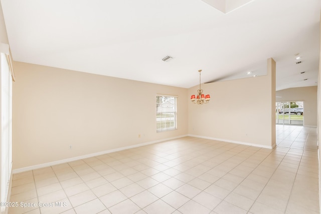 tiled spare room featuring a chandelier, a healthy amount of sunlight, and vaulted ceiling