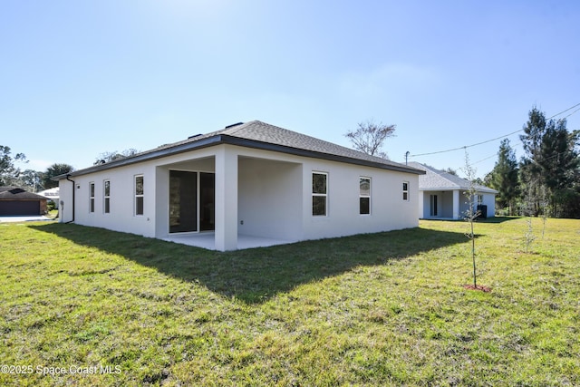 back of house featuring a lawn and a patio