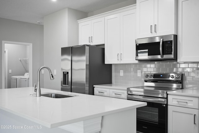 kitchen featuring stainless steel appliances, a center island with sink, white cabinets, and independent washer and dryer