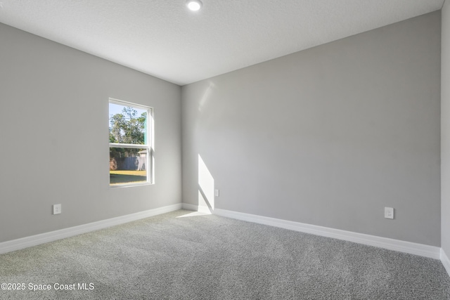 spare room with a textured ceiling and carpet