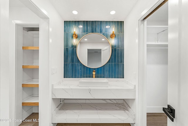 bathroom featuring built in shelves, vanity, and tile walls