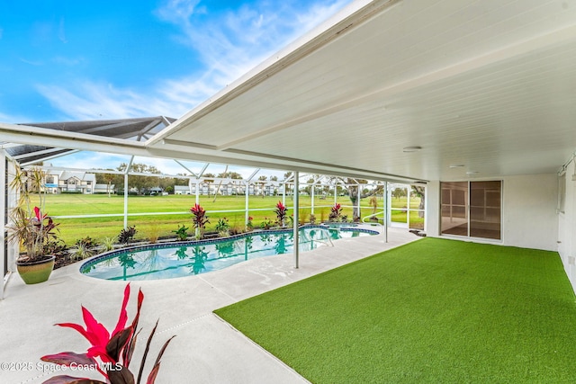 view of swimming pool with a yard, a patio, and a lanai