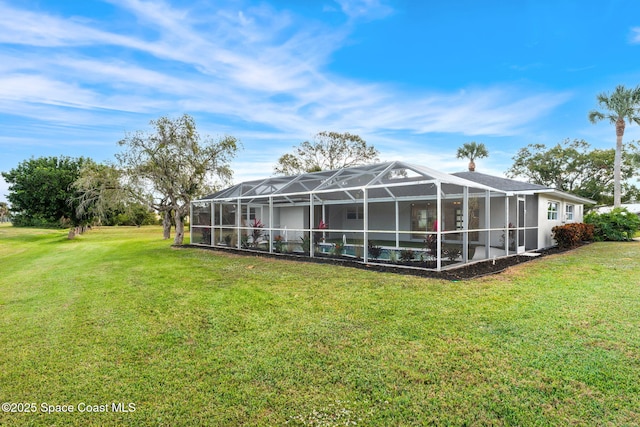 back of house featuring glass enclosure and a yard