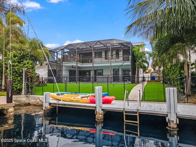 view of dock with glass enclosure and a yard