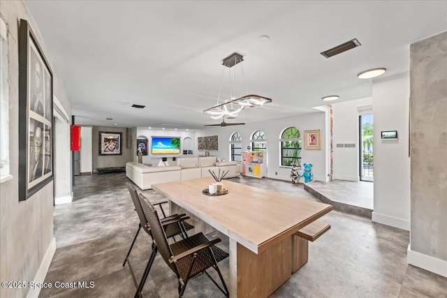 dining room featuring ceiling fan and concrete floors