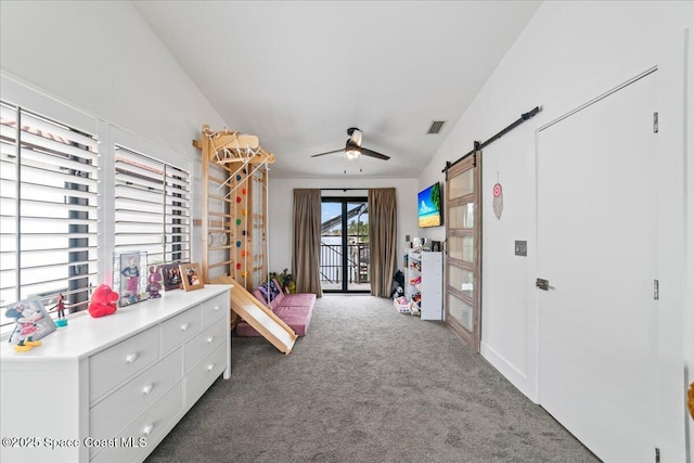 playroom with dark colored carpet, a barn door, ceiling fan, and lofted ceiling