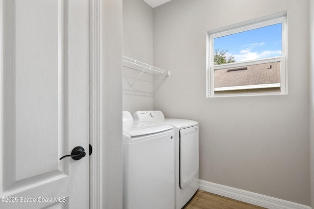 clothes washing area featuring separate washer and dryer and hardwood / wood-style floors