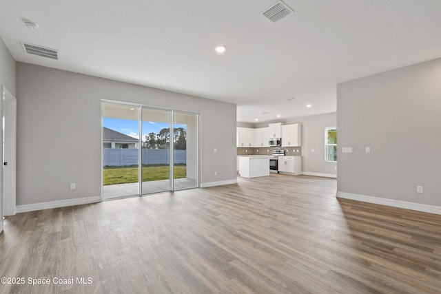 unfurnished living room featuring a wealth of natural light and light wood-type flooring