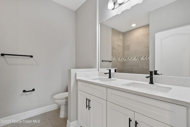 bathroom featuring tile patterned floors, vanity, a tile shower, and toilet