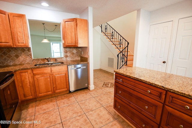 kitchen with tasteful backsplash, sink, stainless steel dishwasher, and decorative light fixtures