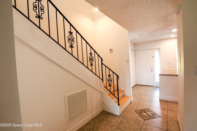 tiled foyer entrance with a textured ceiling