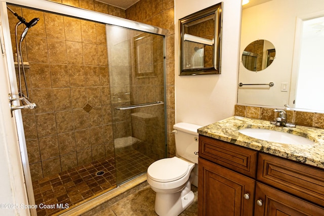 bathroom with an enclosed shower, vanity, toilet, and tile patterned flooring