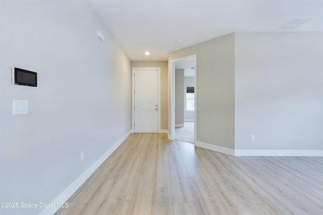 unfurnished room with light wood-style flooring, visible vents, and baseboards