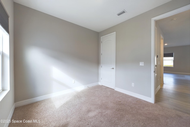 unfurnished bedroom with baseboards, visible vents, and carpet flooring