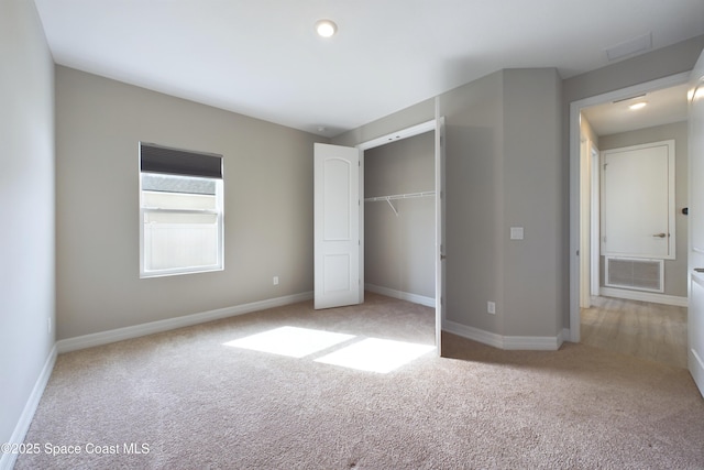 unfurnished bedroom with baseboards, visible vents, a closet, and light colored carpet