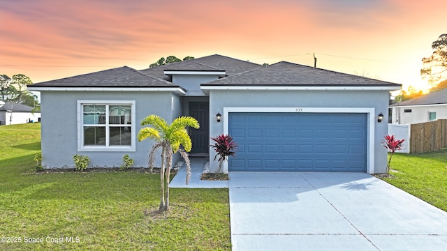 view of front of home featuring a garage, driveway, a front lawn, and roof with shingles