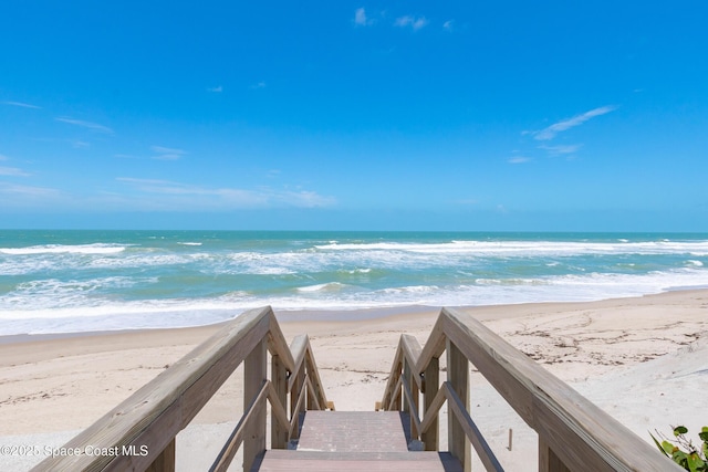 view of property's community with a water view and a view of the beach