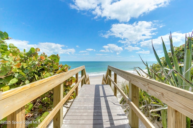 view of community featuring a water view and a beach view