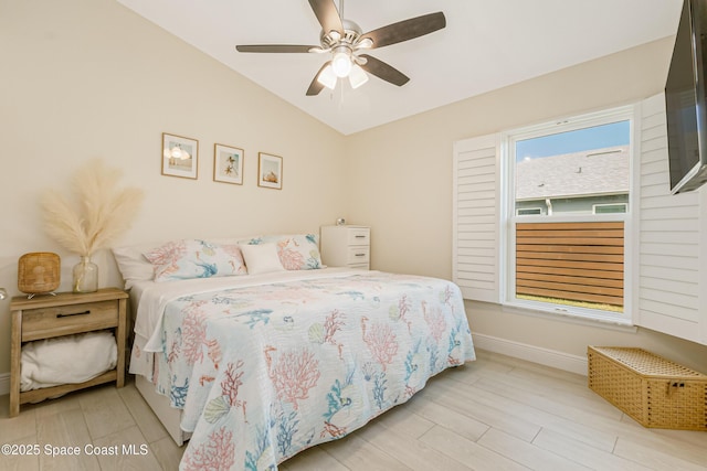 bedroom with ceiling fan, light hardwood / wood-style floors, and lofted ceiling