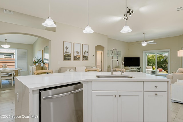 kitchen with pendant lighting, white cabinetry, stainless steel dishwasher, and a center island with sink