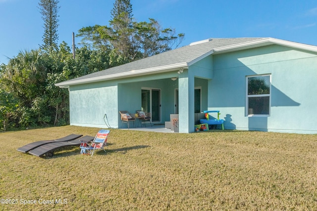 back of property with a yard and a patio